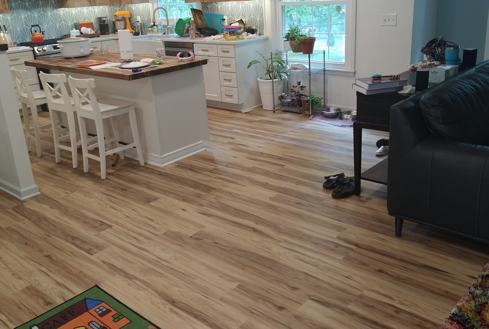 Luxury vinyl plank flooring running through an open kitchen and living room, installed by Forever Flooring